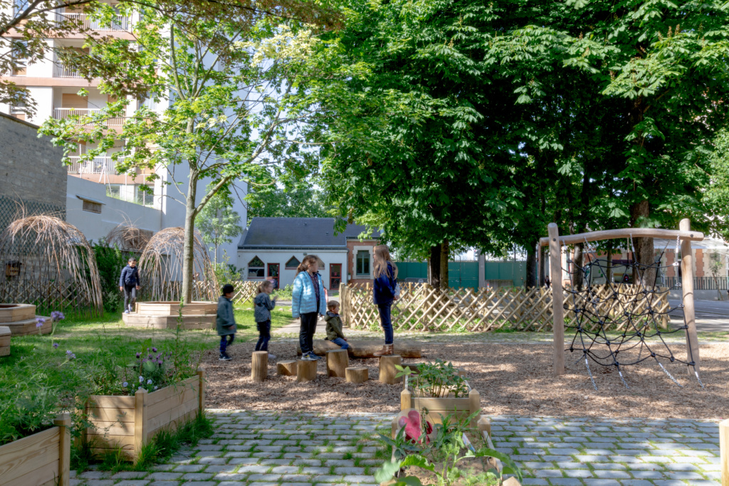 La partie plantée de la cour a été agrandie avec le potager, une aire de jeux en copeaux, des cabanes tressées.