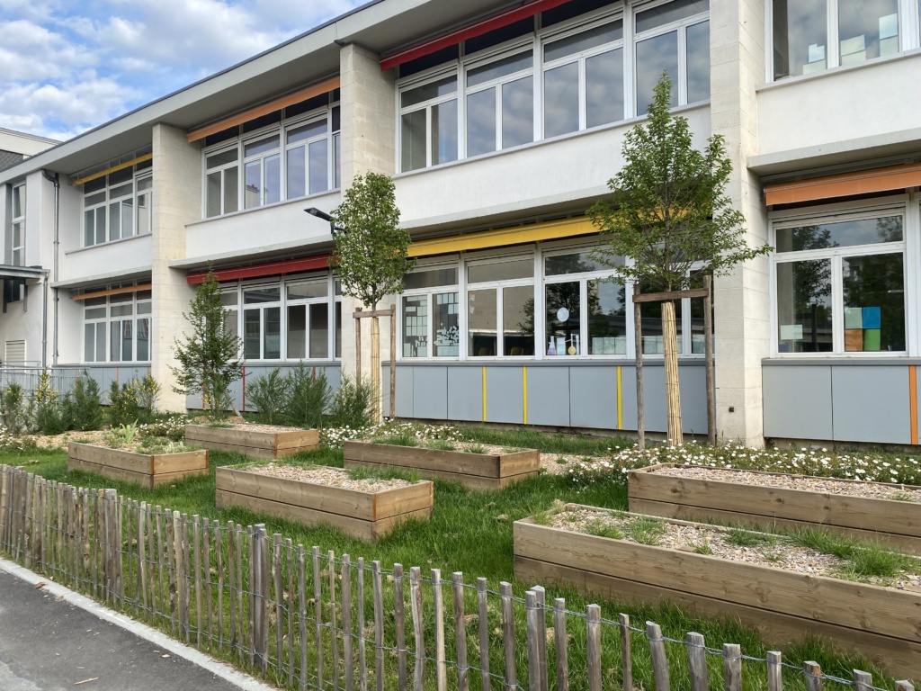 Bacs potagers et plantations le long d'une façade