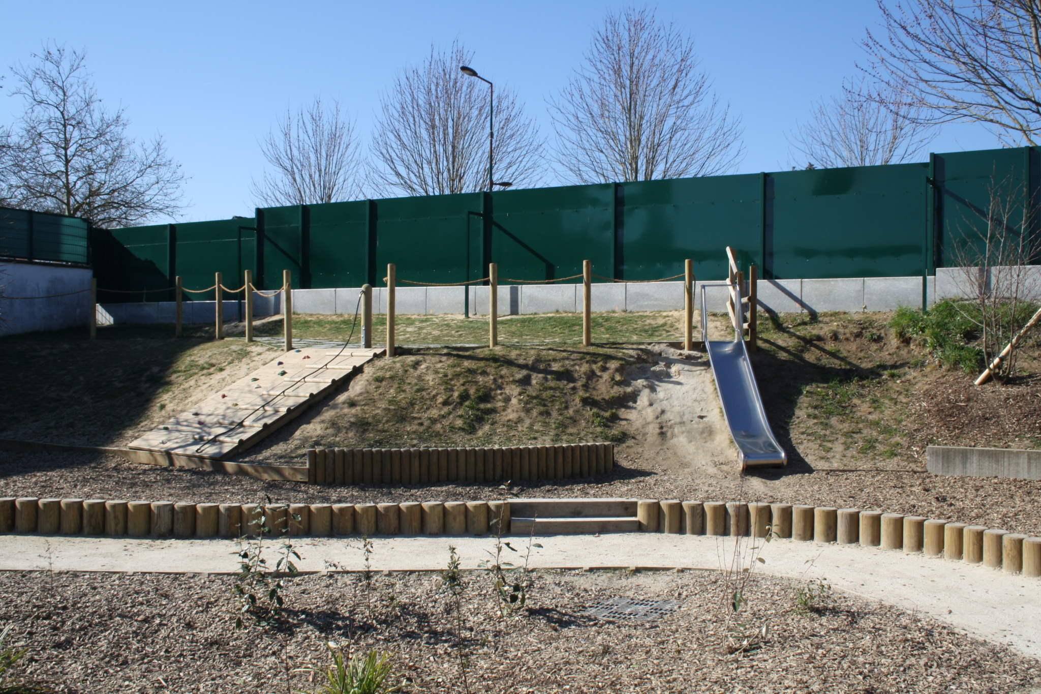 Aménagement du talus avec une structure d'escalade et un toboggan