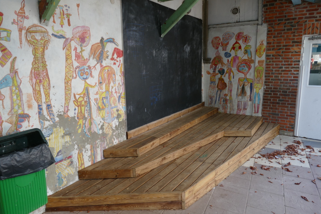 Dans un angle abrité, un tableau d'expression surplombe une estrade.
