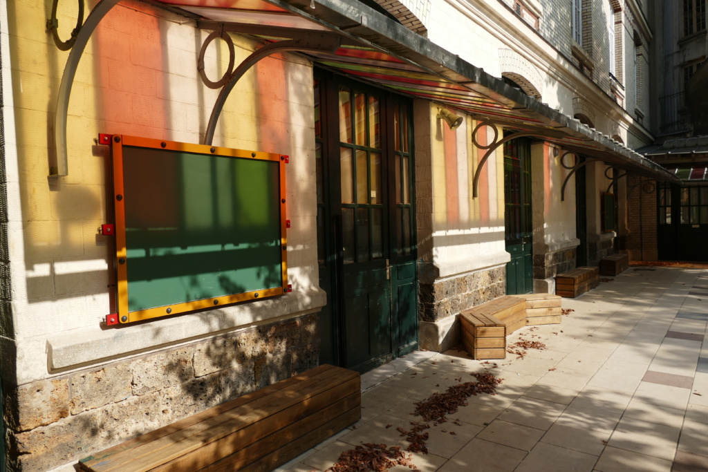 Le long de la façade principale, sous l'auvent coloré, des bancs-coffres ont été installés.