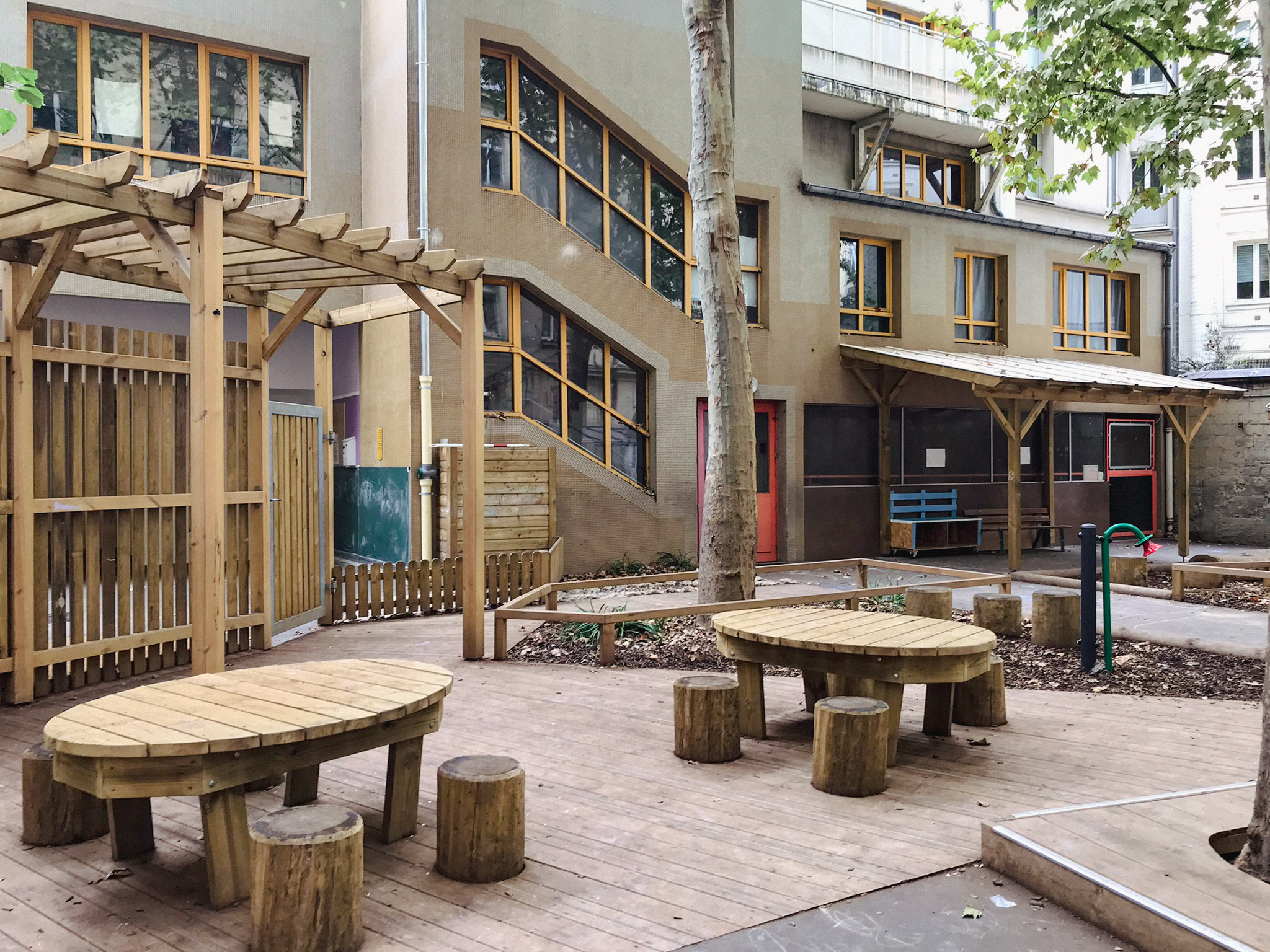 Des espaces calmes pour faire des activités ou classe dehors sont créées sous la pergola et les arbres côté élémentaire